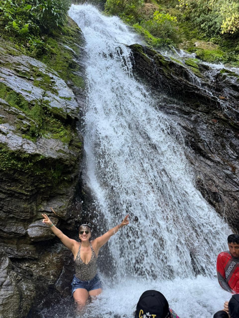 Visitante bajo una cascada natural cerca de Norcasia, Caldas