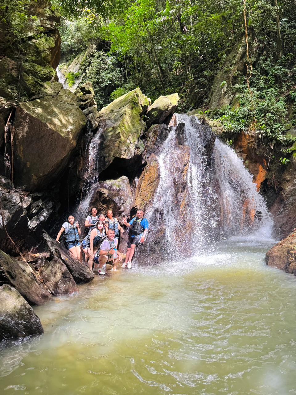 Visitantes disfrutando una cascada natural